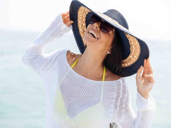 Woman on the beach wearing a sun hat