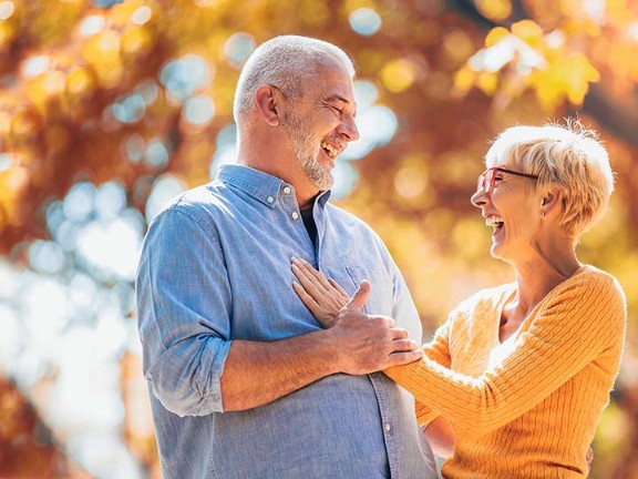 joyful elderly couple embracing each other outdoors