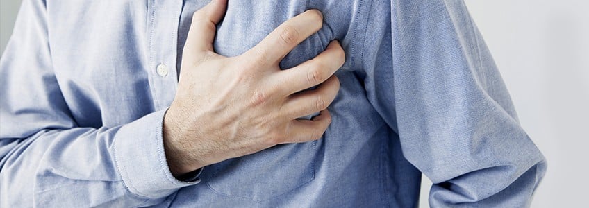 Man clutches his chest as he experiences sudden pain