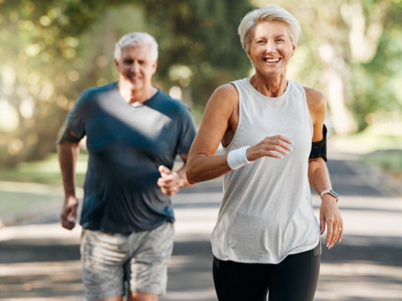 An healthy elderly couple jogging outside