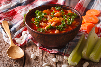 Hearty minestrone soup with carrots, celery, potatoes, cannellini beans, green beans, tomatoes, and kale, a meatless recipe for Lent